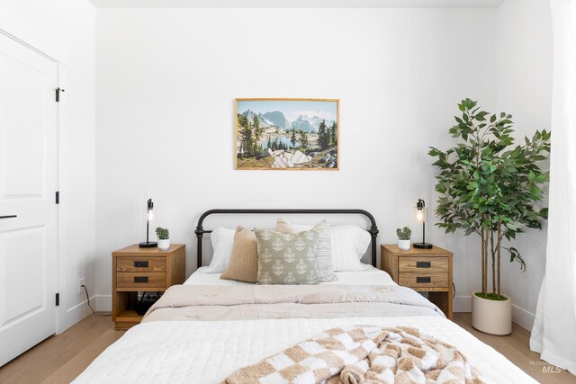 bedroom with wood finished floors and baseboards