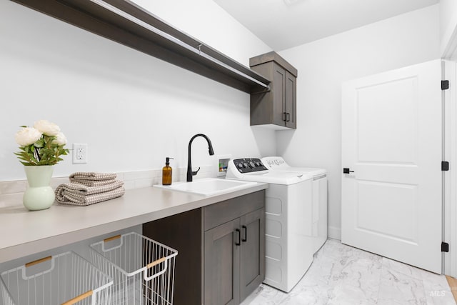 washroom with cabinet space, light marble finish floors, and washing machine and dryer