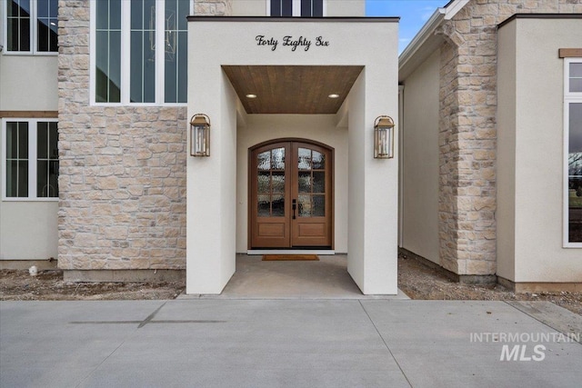 property entrance featuring stone siding and stucco siding