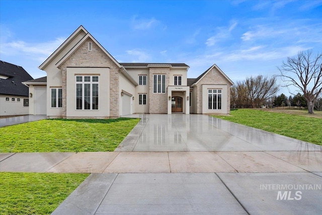 view of front of property featuring a garage, driveway, a front yard, and stucco siding