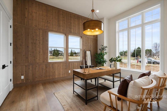 home office featuring wooden walls, baseboards, and wood-type flooring