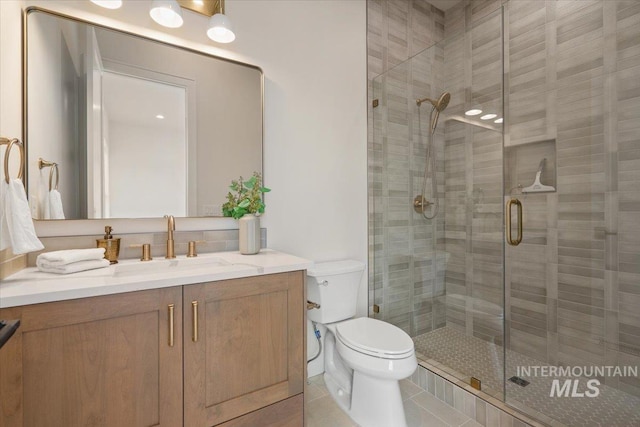 full bath featuring vanity, toilet, a shower stall, and tile patterned flooring