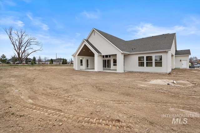 rear view of house featuring a patio area and stucco siding