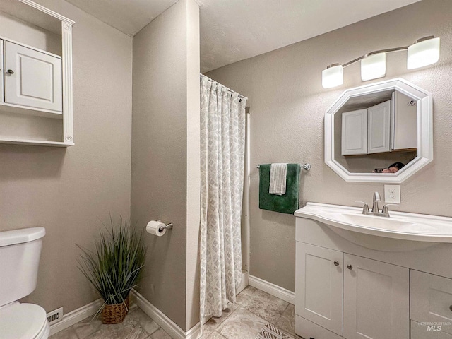 bathroom with vanity, curtained shower, and toilet