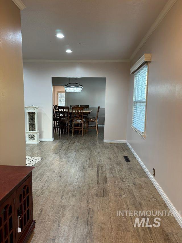 unfurnished dining area with hardwood / wood-style floors and ornamental molding