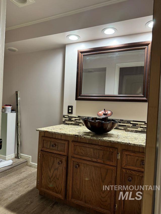 bathroom featuring crown molding, vanity, and hardwood / wood-style flooring