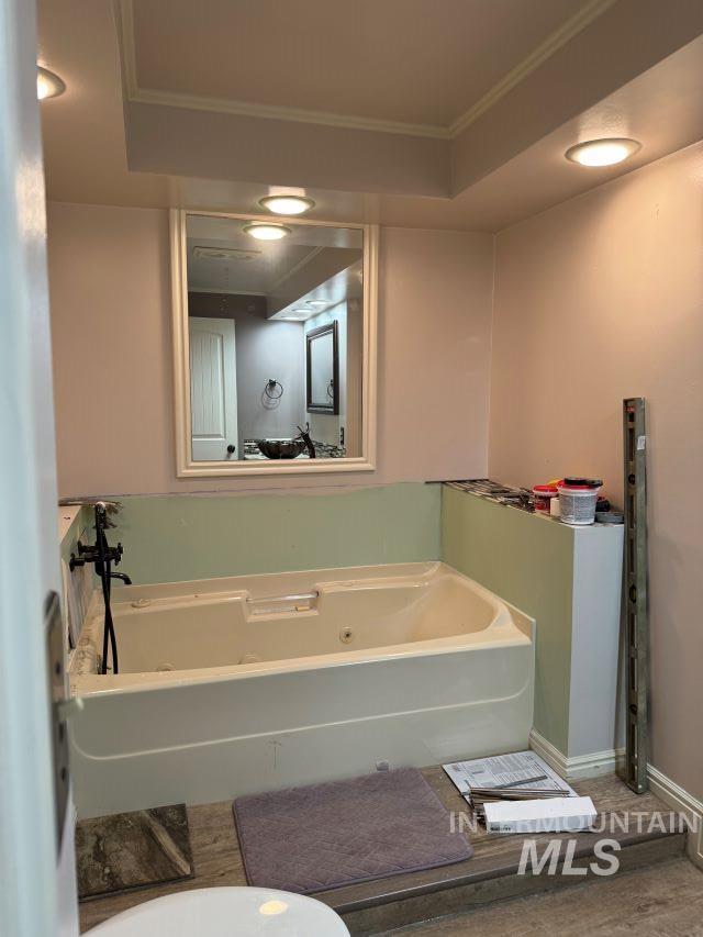 bathroom featuring a washtub and ornamental molding