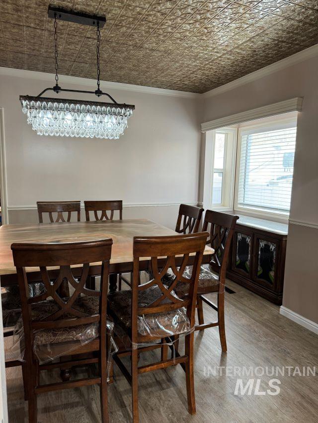 dining space with crown molding and hardwood / wood-style flooring