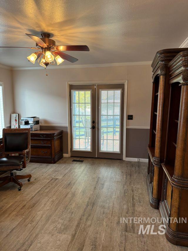 office with french doors, a textured ceiling, ceiling fan, crown molding, and hardwood / wood-style floors