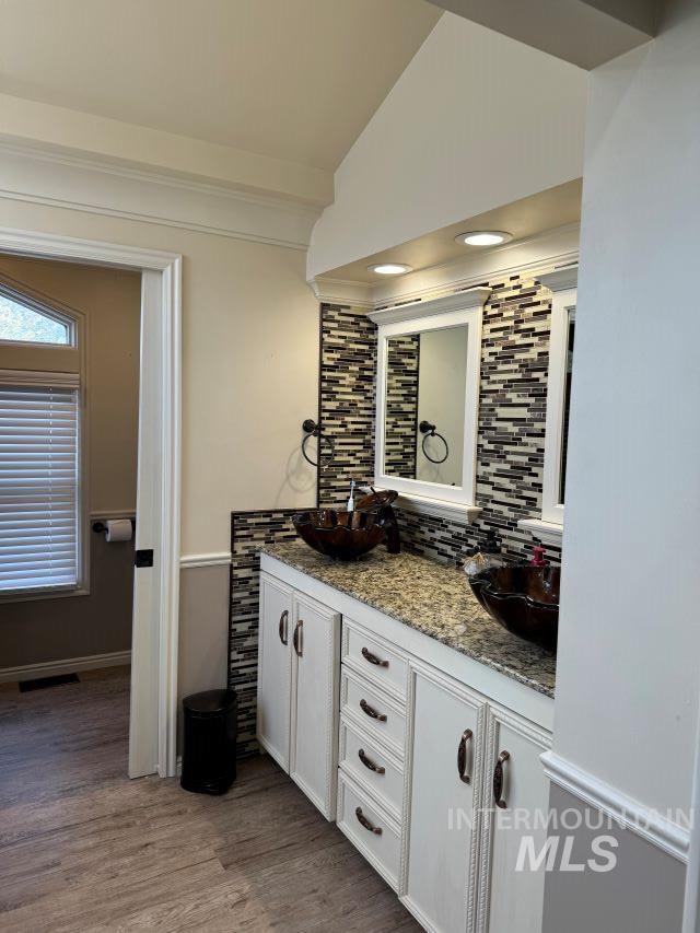 bathroom with hardwood / wood-style flooring, vanity, and lofted ceiling