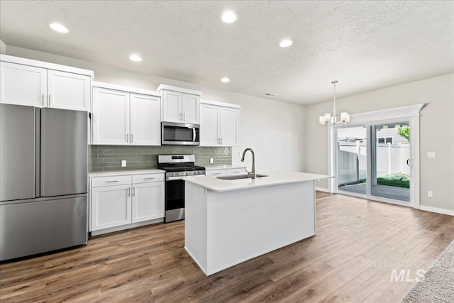 4084 E Blueberry St, Meridian, ID 83642 - kitchen featuring stainless steel appliances, a sink, a textured ceiling, dark wood finished floors, and backsplash