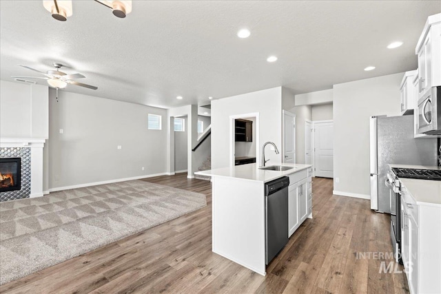 4084 E Blueberry St, Meridian, ID 83642 - kitchen featuring appliances with stainless steel finishes, a sink, open floor plan, a center island with sink, and light wood finished floors