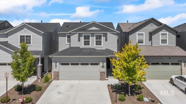 4084 E Blueberry St, Meridian, ID 83642 - view of property with driveway, a garage, stone siding, a residential view, and a shingled roof