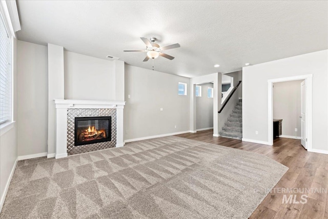 4084 E Blueberry St, Meridian, ID 83642 - unfurnished living room with ceiling fan, a fireplace, wood finished floors, stairway, and baseboards