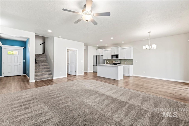 4084 E Blueberry St, Meridian, ID 83642 - unfurnished living room featuring a sink, a chandelier, baseboards, stairs, and recessed lighting