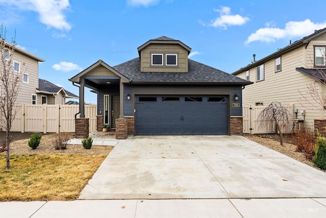 view of front of property with concrete driveway, a gate, a garage, and a shingled roof