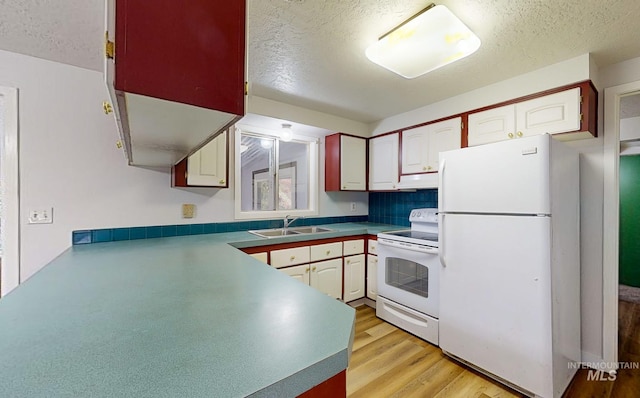 kitchen with white cabinets, a textured ceiling, white appliances, and sink