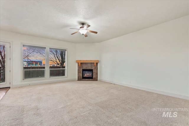 1280 W Bacall St, Meridian, ID 83646 - unfurnished living room with baseboards, a ceiling fan, carpet floors, and a tile fireplace