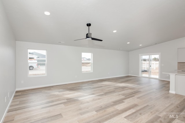 unfurnished living room featuring ceiling fan, vaulted ceiling, and light hardwood / wood-style flooring