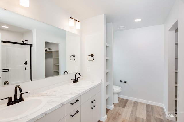 bathroom featuring vanity, an enclosed shower, wood-type flooring, and toilet