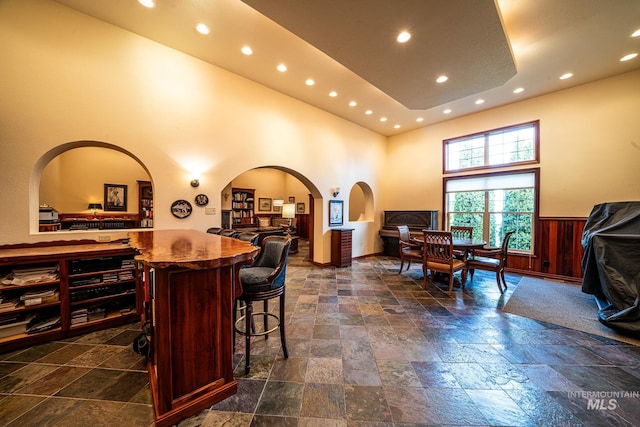 186 Ridgeview Dr, Grangeville, ID 83530 - interior space featuring recessed lighting, a high ceiling, a wainscoted wall, stone tile flooring, and arched walkways