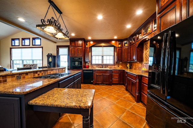 186 Ridgeview Dr, Grangeville, ID 83530 - kitchen with light stone countertops, vaulted ceiling, black appliances, a sink, and backsplash