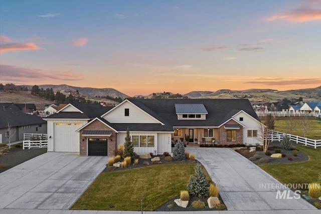 view of front of house with a mountain view, a yard, and a garage