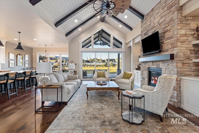 living room with ceiling fan, dark wood-type flooring, a fireplace, high vaulted ceiling, and beam ceiling