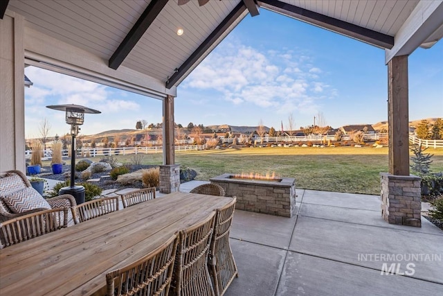 view of patio / terrace with ceiling fan and a fire pit