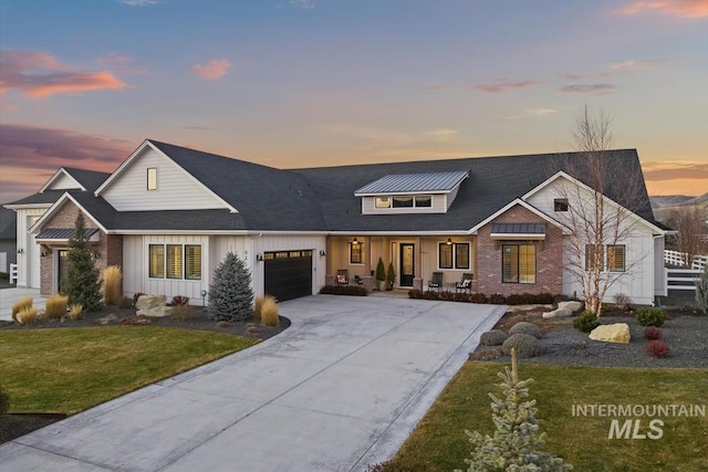 modern farmhouse style home with a garage, a lawn, and covered porch