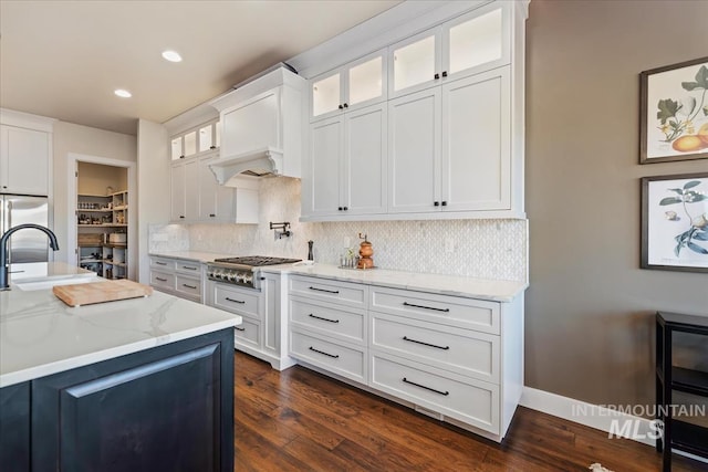 kitchen featuring stainless steel gas stovetop, sink, white cabinetry, dark hardwood / wood-style flooring, and light stone counters