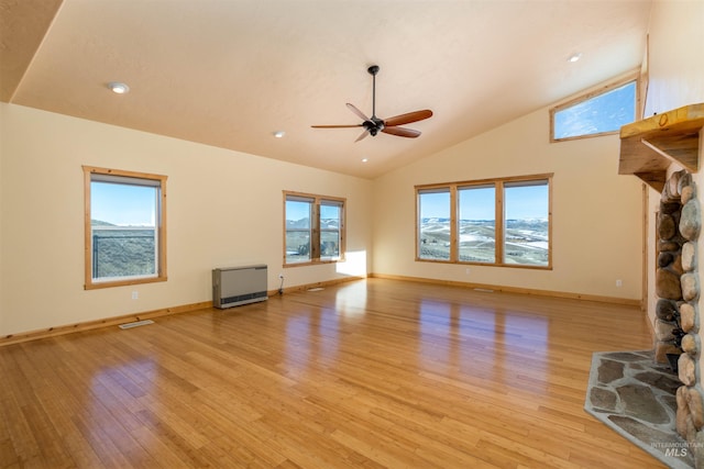 unfurnished living room featuring heating unit, light wood finished floors, baseboards, and a ceiling fan