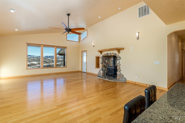 unfurnished living room featuring plenty of natural light, ceiling fan, visible vents, and arched walkways