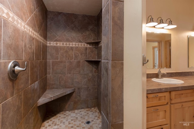 bathroom featuring tiled shower and vanity