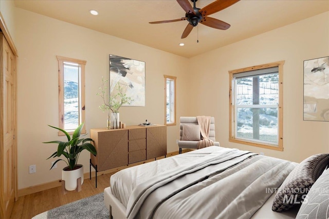 bedroom with baseboards, wood finished floors, and recessed lighting