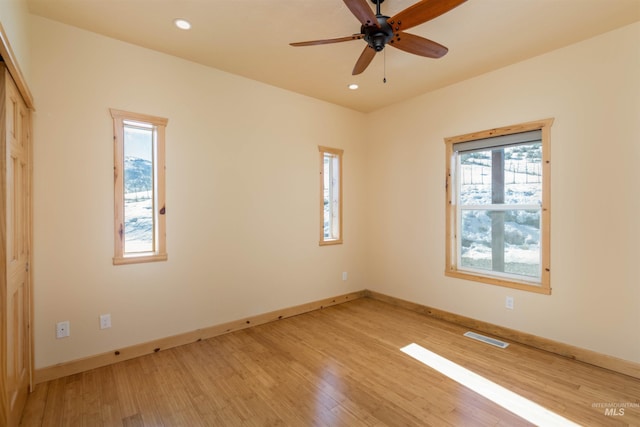 unfurnished room featuring light wood-style floors, recessed lighting, visible vents, and baseboards