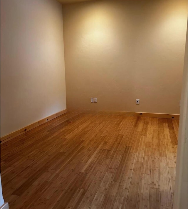 spare room featuring wood finished floors and baseboards