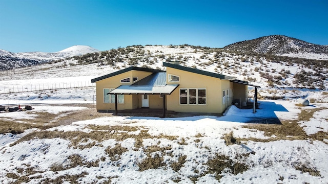 rear view of house with metal roof and stucco siding