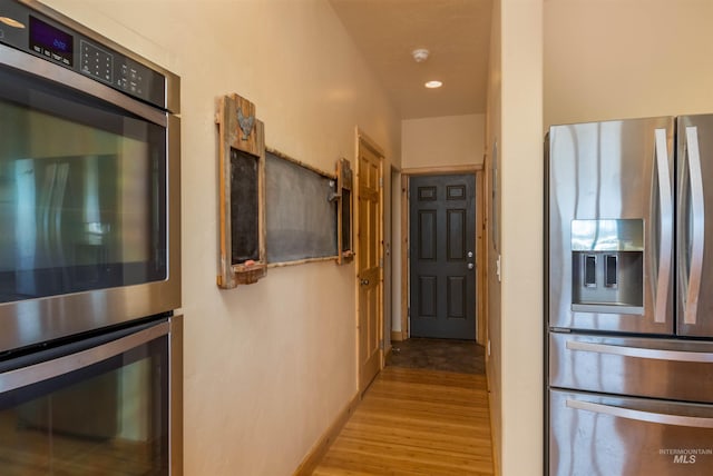 kitchen with appliances with stainless steel finishes, recessed lighting, baseboards, and wood finished floors