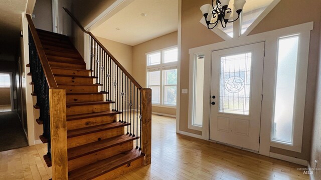 foyer with light wood-type flooring and an inviting chandelier