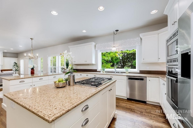 2417 E Brigantine Ct, Eagle, ID 83616 - kitchen featuring appliances with stainless steel finishes, a sink, a peninsula, a center island, and wood finished floors