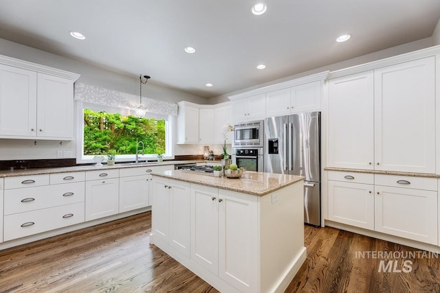 2417 E Brigantine Ct, Eagle, ID 83616 - kitchen with appliances with stainless steel finishes, white cabinetry, dark wood-style floors, a kitchen island, and recessed lighting