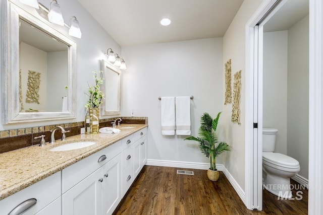 2417 E Brigantine Ct, Eagle, ID 83616 - bathroom with wood finished floors, baseboards, double vanity, toilet, and recessed lighting