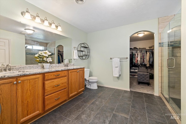 2023 E Wrightwood Dr, Meridian, ID 83642 - bathroom with a stall shower, double vanity, a walk in closet, and baseboards