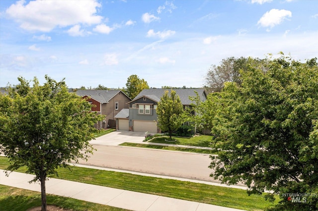2023 E Wrightwood Dr, Meridian, ID 83642 - view of property hidden behind natural elements featuring driveway, a garage, and a front lawn