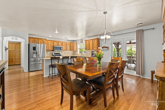 2023 E Wrightwood Dr, Meridian, ID 83642 - dining space featuring light wood finished floors, arched walkways, a chandelier, and recessed lighting