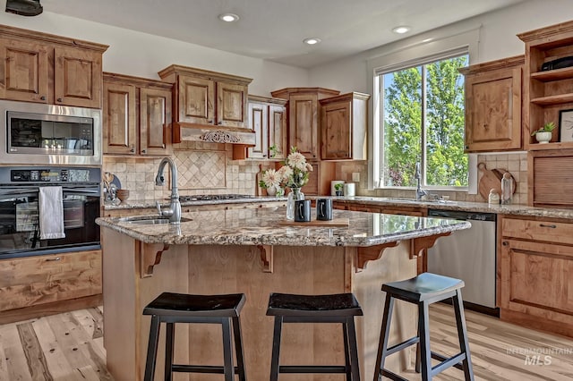 352 N Panorama Pl, Boise, ID 83702 - kitchen featuring stainless steel appliances, open shelves, an island with sink, recessed lighting, and light stone counters