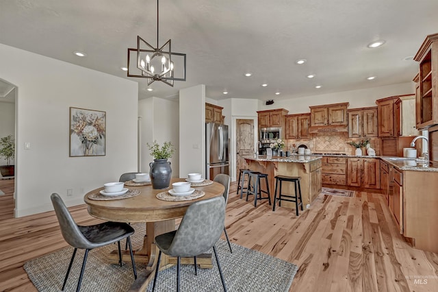 352 N Panorama Pl, Boise, ID 83702 - dining area with light wood finished floors, recessed lighting, a chandelier, and arched walkways