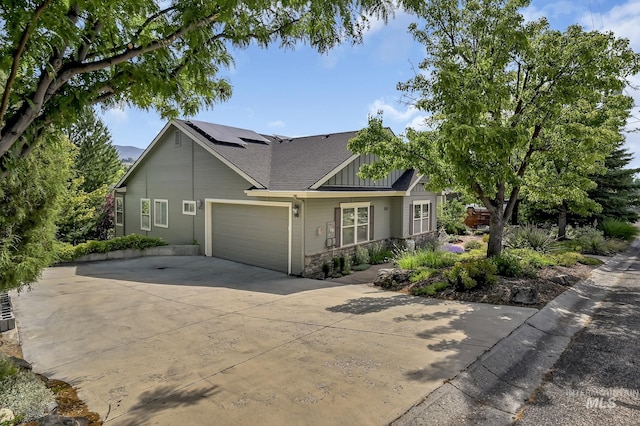 352 N Panorama Pl, Boise, ID 83702 - craftsman house featuring board and batten siding, roof mounted solar panels, a garage, stone siding, and concrete driveway