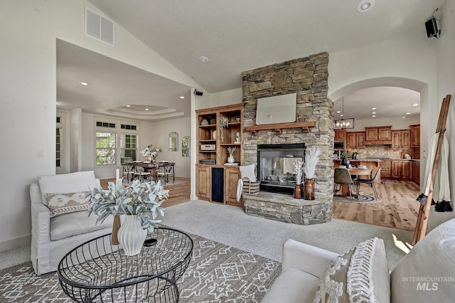 352 N Panorama Pl, Boise, ID 83702 - living room with a fireplace, arched walkways, recessed lighting, lofted ceiling, and light carpet